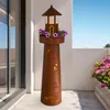 A decorative lighthouse planter with purple flowers on a balcony. Produktbild-Vorschau