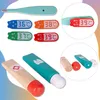 A collection of toy medical instruments, including thermometers and a toothpaste tube, arranged on a light-colored background with subtle color gradients. Anteprima dell’immagine prodotto