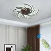 A modern ceiling light fixture with a swirling design, mounted on a white ceiling. A remote control is shown in the foreground, with a blue Wi-Fi symbol overlay. Anteprima dell’immagine prodotto