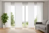 A living room with a large window covered by white panel blinds, a sofa, and a potted plant. Produktbild-Vorschau