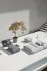An outdoor lounge area with modern furniture and a small tree. Podgląd zdjęcia produktu