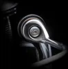 A close-up, macro shot of a metal screw on a shiny metallic component, set against a dark, blurred background. Náhled obrázku produktu