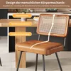 A close-up of a brown faux leather dining chair with a rattan back, placed next to a wooden table in a kitchen setting. Text overlays highlight ergonomic features. Produktbild-Vorschau
