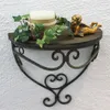 A wall shelf with a candle, ivy, and a cherub figurine. Produktbild-Vorschau