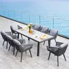 An outdoor dining set with chairs and a table on a patio overlooking the ocean. Náhľad obrázku produktu
