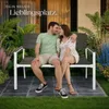 A couple sitting on a garden bench in a backyard setting. Náhled obrázku produktu