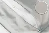 Close-up of a zipper on a light gray fabric product, with a magnified view of the fabric texture in a circle. Produktbild-Vorschau