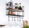 A wall-mounted kitchen shelf with various jars and bottles, and mugs hanging from hooks. Anteprima dell’immagine prodotto