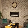 A living room scene with a sofa, coffee table, and a decorative fireplace on a patterned wall. Náhled obrázku produktu