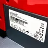 A close-up of a label on a red and gray appliance. Voir les images du produit