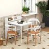 A white folding table with shelves is set up in a kitchen or dining area, with chairs around it. Náhľad obrázku produktu
