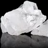 A close-up studio shot of several pieces of clear, rough quartz crystals against a black background, with their reflection visible below. Podgląd zdjęcia produktu