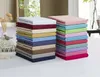 Two stacks of folded bed sheets in various colors, displayed on a white surface. Produktbild-Vorschau