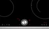 A close-up, top-down view of a black electric hob with silver controls and red digital displays. Náhled obrázku produktu