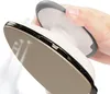 A hand is holding a mini steam iron, and steam is coming out of the iron. Produktbild-Vorschau