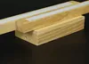 Two wooden LED light fixtures are shown on a dark surface. Produktbild-Vorschau