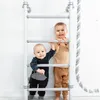 Two young children are standing on a white and gray climbing ladder indoors. Voir les images du produit