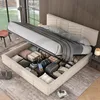 A bed with its storage compartment open, revealing various items stored inside, in a bedroom setting. Produktbild-Vorschau