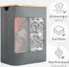 A grey laundry basket with a wooden top, featuring a window showing laundry inside and icons indicating features. Produktbild-Vorschau
