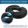A black donut-shaped cushion is shown with a close-up inset and text overlays. Produktbild-Vorschau