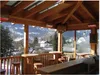 An outdoor seating area with a view of a snowy village. Produktbild-Vorschau