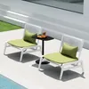 Two lounge chairs with green cushions and pillows are placed on a patio next to a small black table with a fruit platter and drinks. Anteprima dell’immagine prodotto