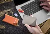 A person's hands are shown using a laptop, with various storage devices and a USB drive placed on a textured surface. Voir les images du produit