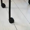 A close-up of a transparent floor mat with black casters of a chair on it, placed on a light wood-grain floor. Náhled obrázku produktu