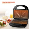 A sandwich maker is open, showing its heating plates. Beside it are plates with sandwiches, salad, strawberries, and a glass of orange juice. Produktbild-Vorschau