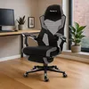 A gaming chair is placed in a home office setting next to a desk and a window. Náhled obrázku produktu