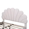 A close-up view of a white upholstered headboard with a shell-like design, attached to a bed frame. Produktbild-Vorschau