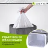 A hand is placing a white laundry bag into a gray bamboo laundry basket. Náhľad obrázku produktu