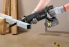 A person wearing work gloves is using a cordless reciprocating saw to cut a metal pipe. The saw has a battery attached, and the pipe is supported by a wooden structure. Produktbild-Vorschau