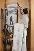 A woman is organizing blankets with ski motifs in a wooden closet. Produktbild-Vorschau