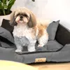 A Shih Tzu dog stands on a gray dog bed with brown accents. Voir les images du produit