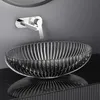 A modern bathroom sink setup with a glass basin and a wall-mounted faucet. Náhľad obrázku produktu