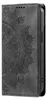 A close-up, side view of a black phone case with a mandala design embossed on it. Produktbild-Vorschau
