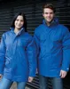 Two people wearing blue parkas standing in front of a black corrugated metal door. Produktbild-Vorschau