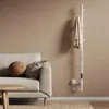 A modern living room scene with a sofa, coffee table, and a white tree-shaped towel warmer. Produktbild-Vorschau