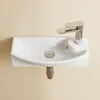 A white ceramic sink with a chrome faucet mounted on a textured beige wall. Produktbild-Vorschau