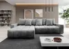 A modern living room with a large sectional sofa, coffee table, and shelving unit.