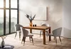 A dining table and chairs set in a modern dining room with large windows. Produktbild-Vorschau
