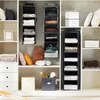 A closet organizer with various shelves and hanging storage units filled with folded clothes and decorative items. Produktbild-Vorschau
