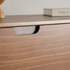 A close-up view of a wooden drawer with a carved handle and a book on top. Produktbild-Vorschau
