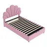 A pink upholstered bed frame with a seashell-shaped headboard is shown from a diagonal angle against a white background. Anteprima dell’immagine prodotto
