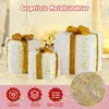 Three illuminated gift boxes with gold ribbons and bows, decorated with glitter, are displayed indoors with a soft, festive background. Below the gift boxes are three circular icons with text labels. Podgląd zdjęcia produktu