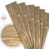 Several planks of wood-like material are fanned out against a white background, with a close-up inset of the wood grain. Náhled obrázku produktu