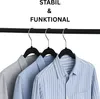 Three shirts are hanging on hangers from a clothes rack. Produktbild-Vorschau