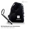 A keychain and a velvet bag are displayed against a white background. Voir les images du produit