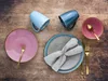 A flat lay of dinnerware set on a wooden table. Náhľad obrázku produktu